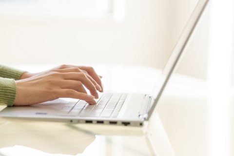 Hands typing on laptop keyboard.