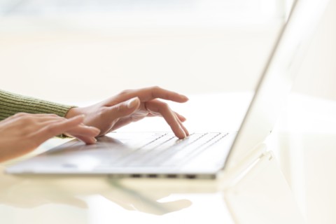 Hands typing on laptop keyboard.