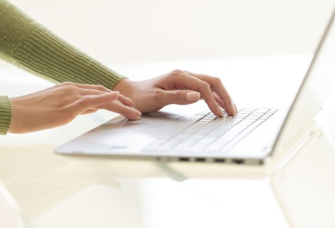 Hands typing on laptop keyboard.