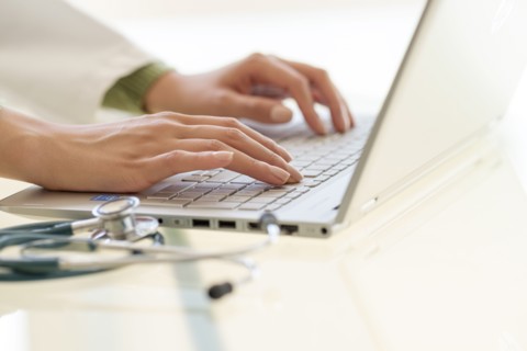 Hands typing on laptop keyboard.
