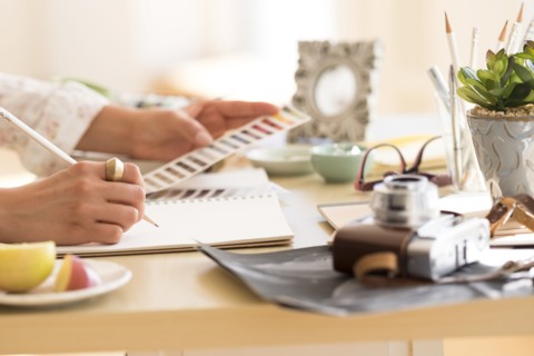 Young woman writing in note pad.