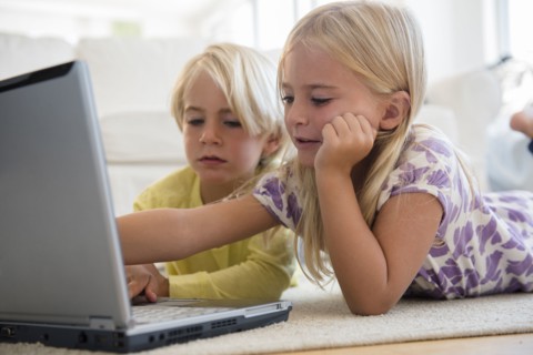 Boy (4-5) and girl (6-7) using laptop