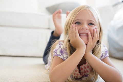 Girl (6-7) lying on floor