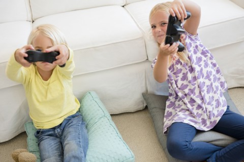 Boy (4-5) and girl (6-7) playing video game