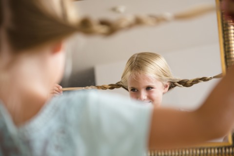 Girl (6-7) reflecting in mirror