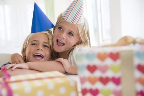 Brother (4-5) and sister (6-7) in embrace at birthday party