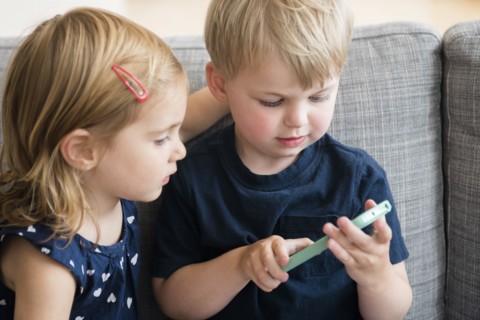Brother with sister (2-3) playing with smart phone