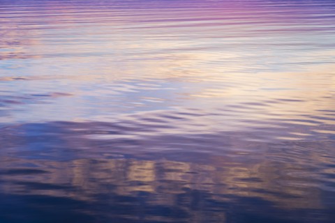Rippled water reflecting colorful light