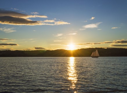 Tranquil seascape with sailboat at sunrise