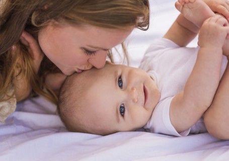 Mother kissing baby (6-11 months)