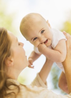 Mother holding up baby boy (6-11 months)
