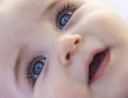 Close-of baby boy's (6-11 months) smiling face