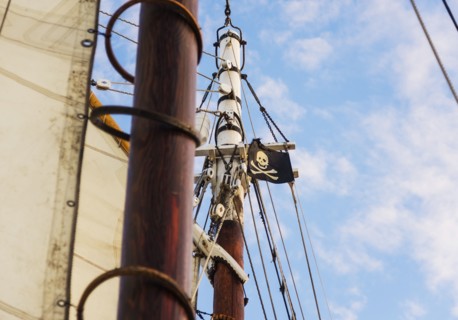 Close-up of sailboat's mast and pirate flag