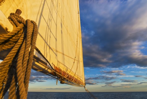 Sail and ropes against sunset sky