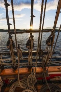 Ropes on sailboat against sunset sky