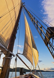 Sail and ropes against sunset sky