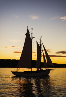 Silhouette of sailboat against sunset sky