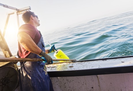 Fisherman throwing lobster buoy