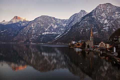 Town and mountains reflecting in lake