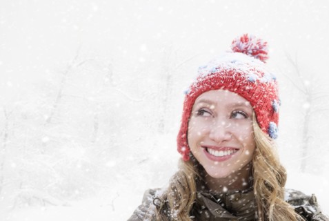 Woman in red knit hat looking away.