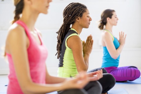 Women in lotus position meditating.