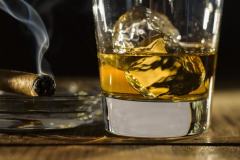 Whiskey and cigar on table.