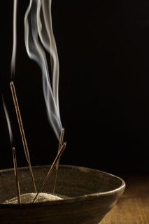Incense in bowl on black background.