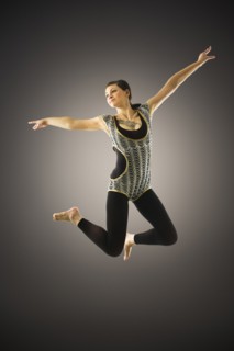 Young woman jumping on black background.