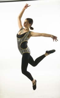 Young woman jumping on black background.