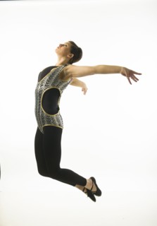 Young woman dancing against white background.