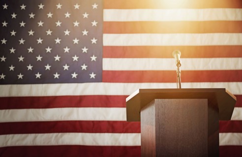 Lectern with American flag in background.