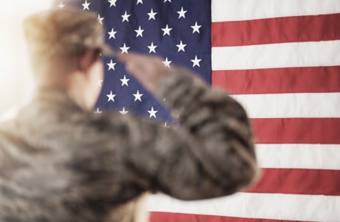 Soldier saluting American flag.
