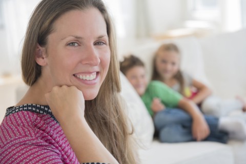 Portrait of mid adult woman with children (6-7, 8-9) in background