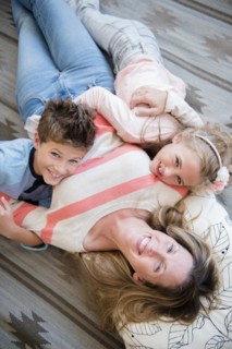 Mother lying down with son (8-9) and daughter (6-7)