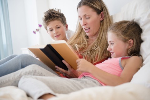 Mother reading with daughter (6-7) and son (8-9)