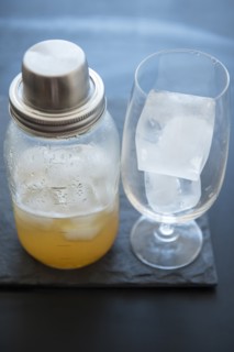 Ice cubes in drinking glass and cocktail shaker