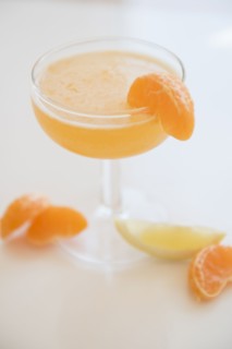 Cocktail in drinking glass and slices of tangerines and lemon