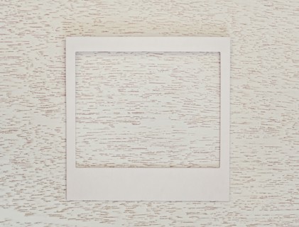 Empty Polaroid frame on textured wood