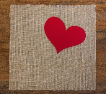 Linen cloth with textile heart shape on table