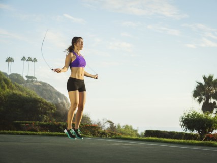 Young woman jumping rope in park