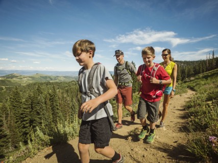 Family with two children (10-11, 12-13) hiking in mountains