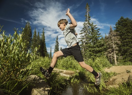 Boy (12-13) jumping in forest