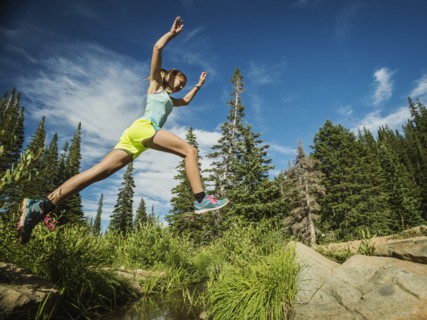 Teenage girl (14-15) jumping in forest
