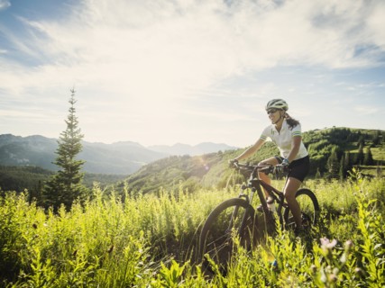 Woman during bicycle trip in mountain scenery