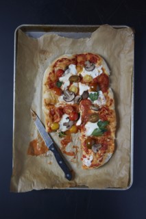 Homemade pizza on baking sheet