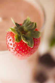 Close-up of strawberry, chocolate smoothie in background