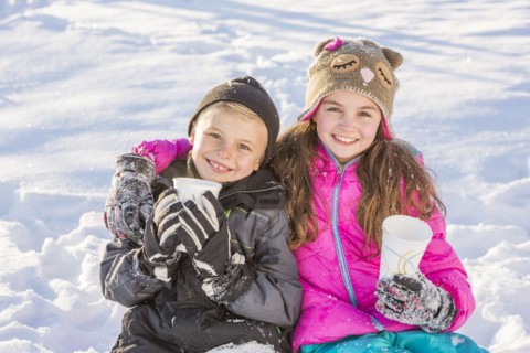 Boy (8-9) and girl (10-11) warming up drinking hot chocolate