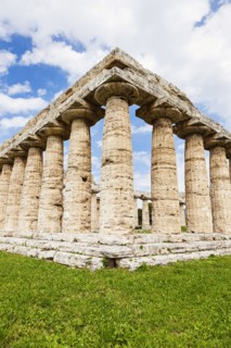 Old architectural columns of Paestum ruins on grass