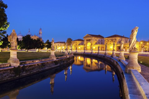 Illuminated Prato della Valle with statues at dusk