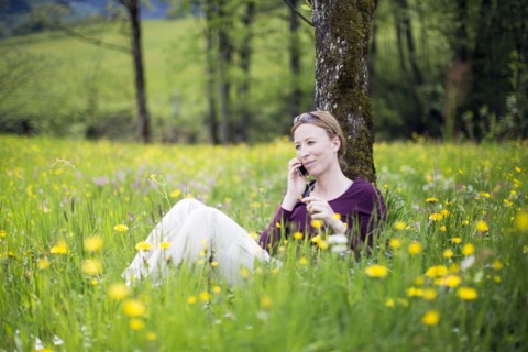 Woman talking on phone in meadow